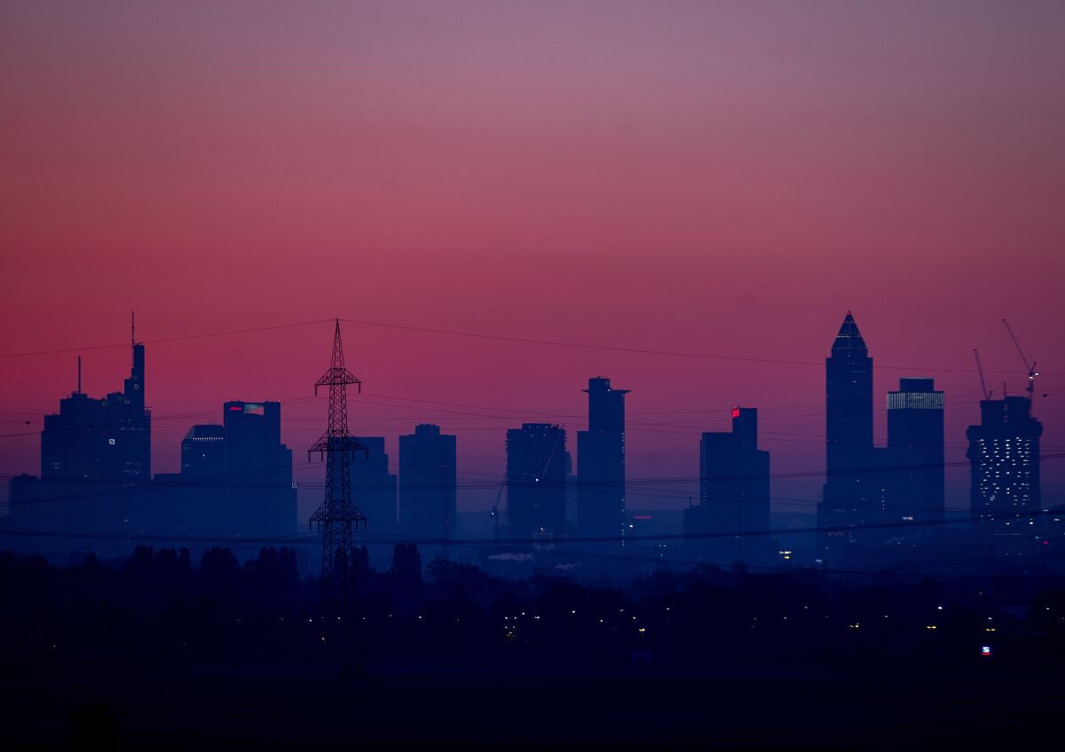 The buildings of the banking district are seen under a red sky before sunrise in Frankfurt, Germany, early Saturday, Nov. 7, 2020. (AP Photo/Michael Probst)