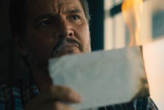 A man looks at a burned piece of paper.