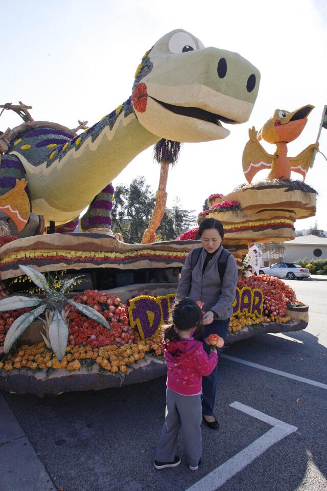 Lin Chen, top, gives a flower to her daughter, Eleni Koutsoukos, 4, after visiting the Dino-Soar float at Memorial Park in La Canada on Saturday, January 5, 2013.