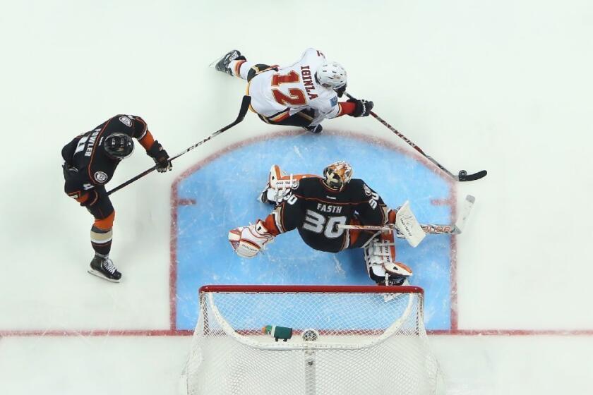 Jarome Iginla is pursued by Cam Fowler of the Ducks as goaltender Viktor Fasth defends his net in the Flames-Ducks game on March 8.