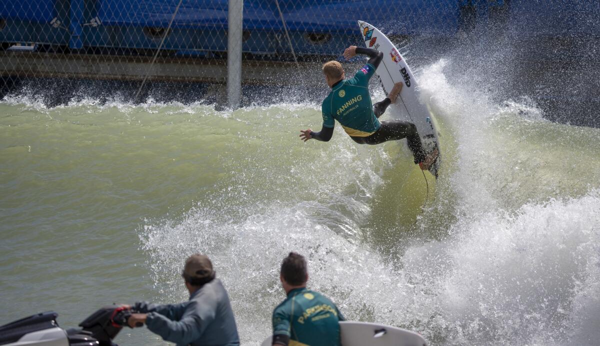 Mick Fanning, of Australia, turns high off the top of a wave during a practice session before the Founder's Cup.