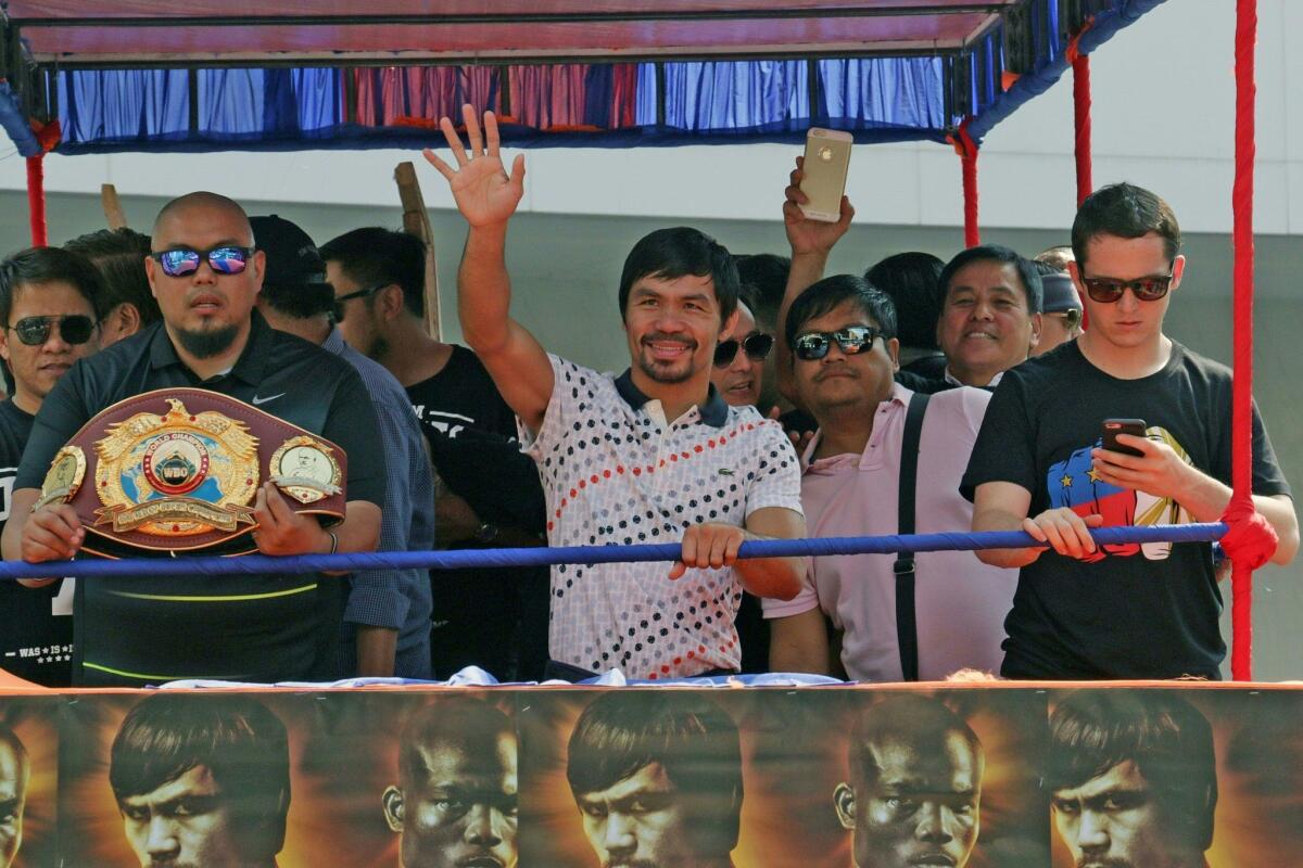 Manny Pacquiao waves to supporters during a parade in Manila on April 14.