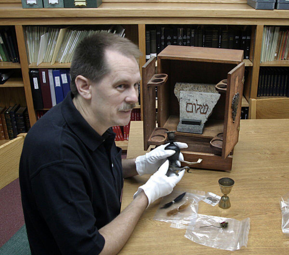 Jason Haxton shows the contents of the box with the long mysterious history.
