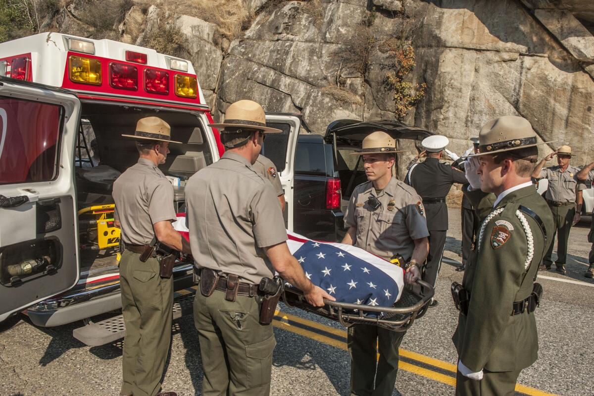 Yosemite National Park rangers transfer the body of a pilot who was killed when his air tanker crashed fighting a wildfire a day earlier.