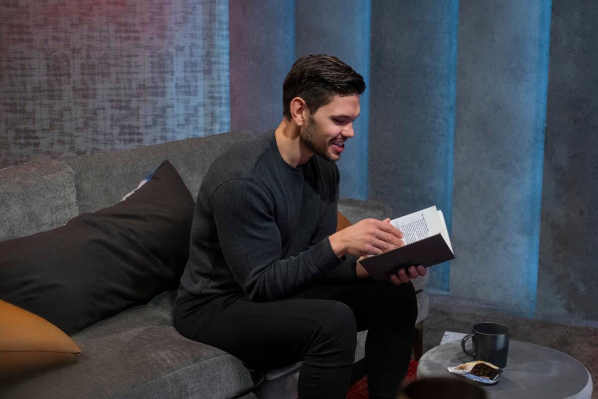 A male participant in Season 2 of "Love Is Blind" looking at his notebook.