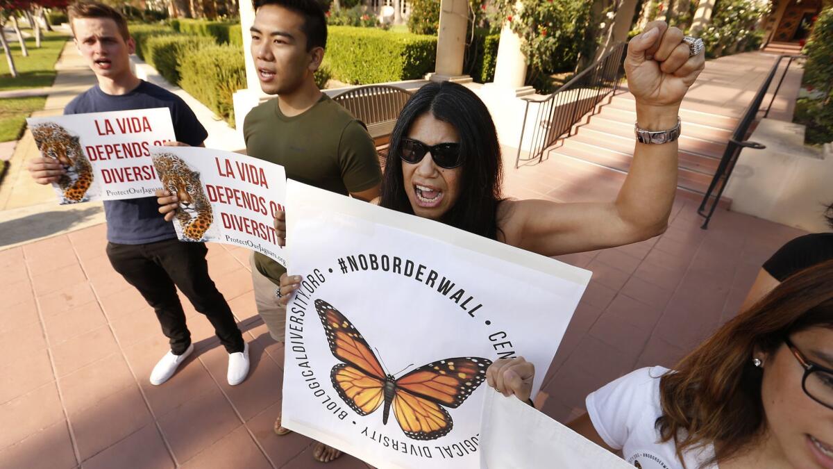 Protesters Will Goebel, from left, Rolando Delmundo, Yolanda Brown and Liz Martinez rally Tuesday outside the U.S. 9th Circuit Court of Appeals in Pasadena, where justices heard arguments in a case involving the Trump administration's effort to build a border wall.