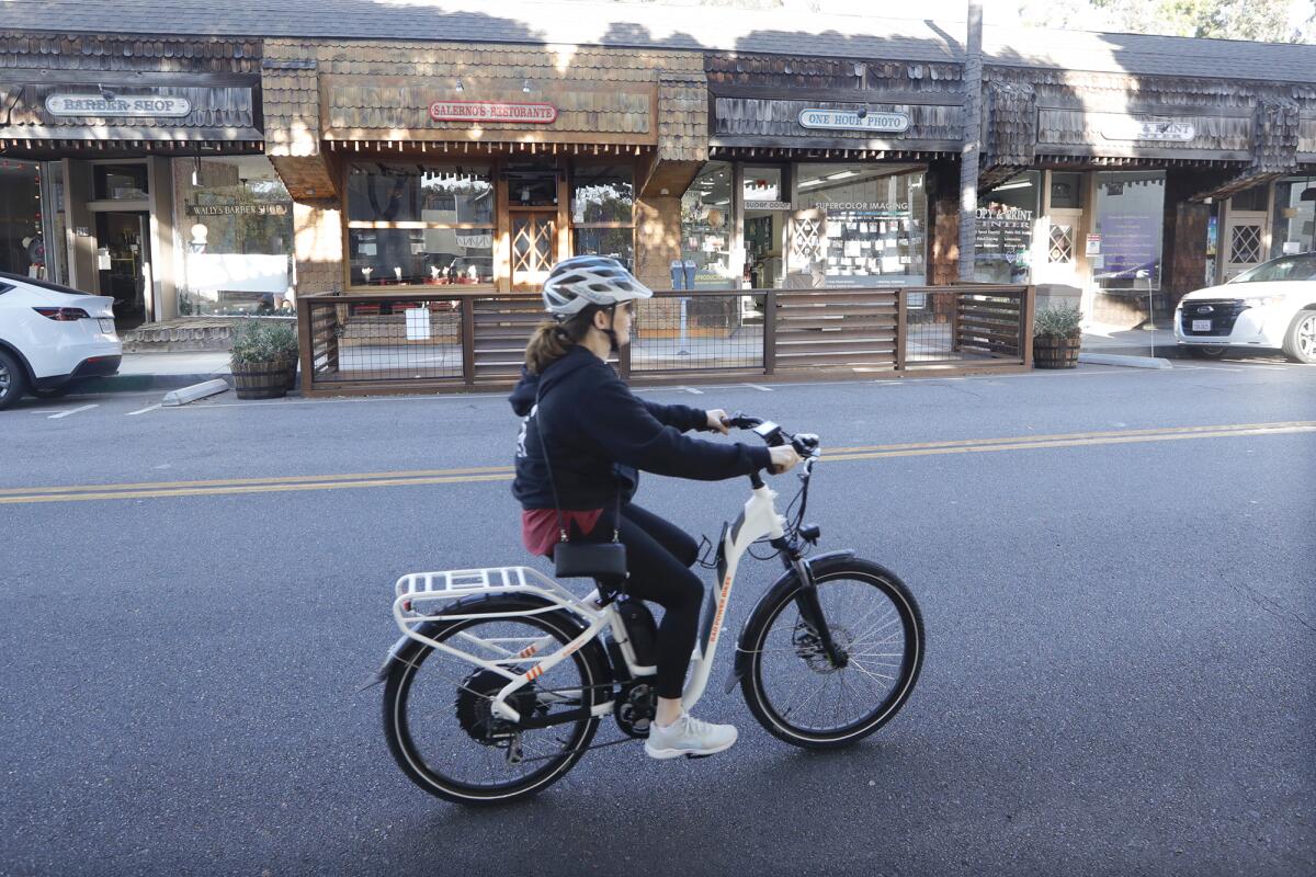 An e-bike rider cruises on Beach Street in downtown Laguna Beach in 2021. 