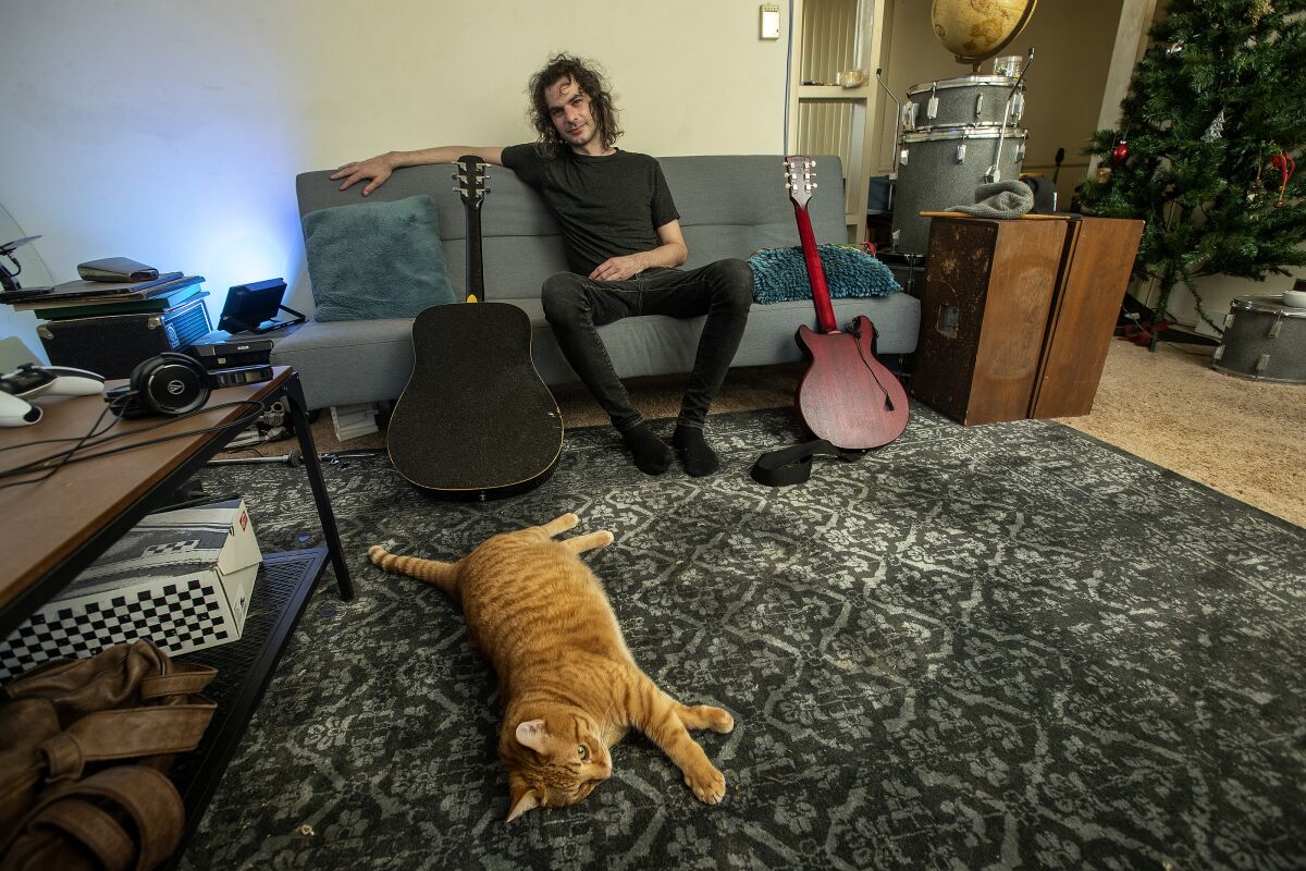 Rob Leonard with his cat inside his apartment in Santa Monica.