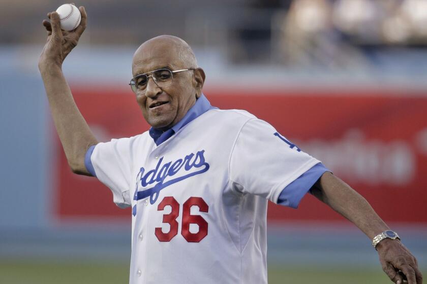 FILE - In this July 1, 2014, file photo, former Los Angeles Dodgers pitcher Don Newcombe throws a ceremonial pitch before a baseball game between the Los Angeles Dodgers and the Cleveland Indians, in Los Angeles. Newcombe, the hard-throwing Brooklyn Dodgers pitcher who was one of the first black players in the major leagues and who went on to win the rookie of the year, Most Valuable Player and Cy Young awards, has died. He was 92. The team confirmed that Newcombe died Tuesday morning, Feb. 19, 2019, after a lengthy illness. (AP Photo/Chris Carlson, File)