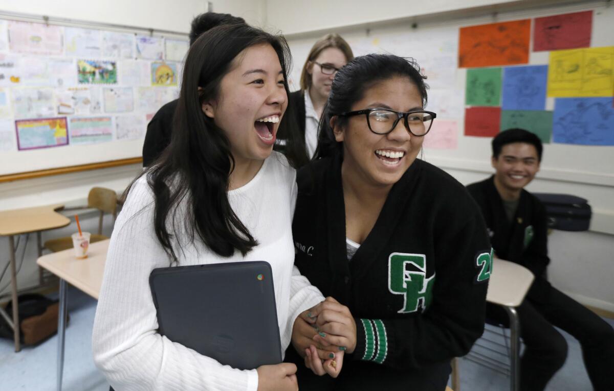 Isabel Mercado, 17, and Tamara Cruz, 16, students at Granada Hills Charter High School, react to hearing the scores of the alternates on their team who participated in the online version of the U.S. Academic Decathlon.
