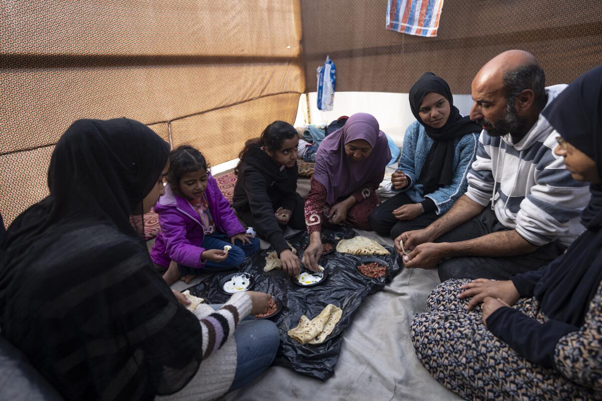 Family eating breakfast in makeshift tent camp in Gaza