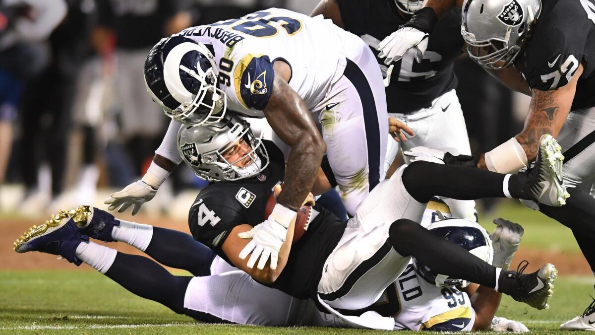 Rams Aaron Donald and Michael Brockers (90) sack Raiders quarterback Derek Carr but a roughing a passer penalty is called in the first quarter.