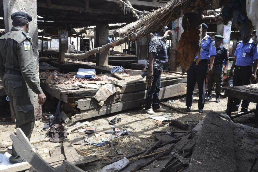 Police officers inspect the site of a suicide bomb attack at a market in Maiduguri, Nigeria, on June 2.