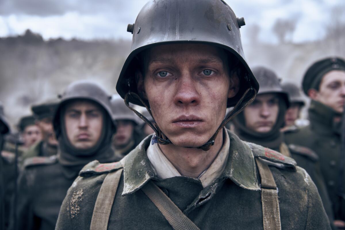 Still of serious-looking soldiers from film "All Quiet on the Western Front"