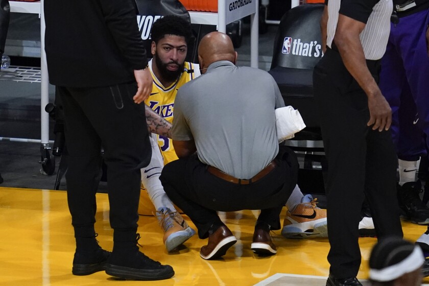 Los Angeles Lakers forward Anthony Davis (3) is checked out for injury during the first quarter of Game 6 of an NBA basketball first-round playoff series Thursday, Jun 3, 2021, in Los Angeles. Davis let the court. (AP Photo/Ashley Landis)