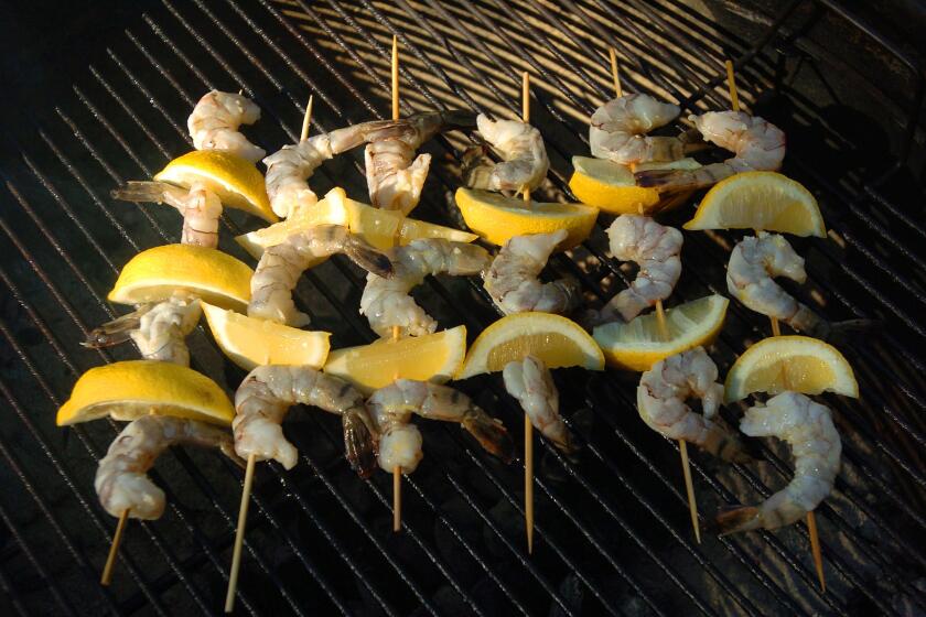 Lemon shrimp kabobs are barbequed on the grill for the party.