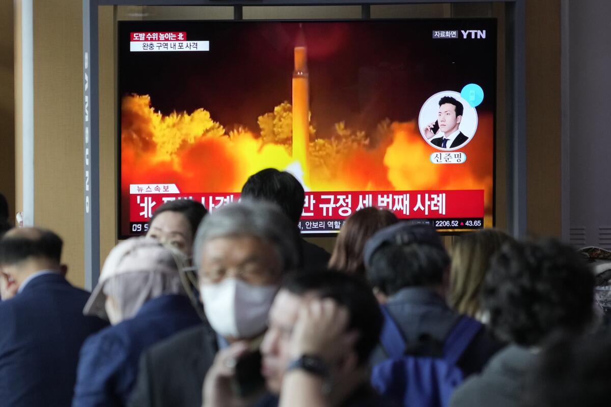A TV screen shows a file image of North Korea's missile launch during a news program.