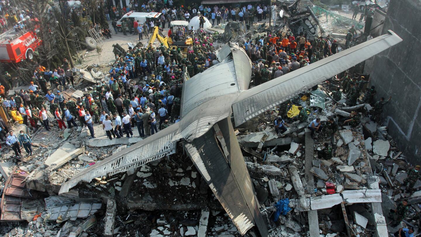 Rescuers search for victims at the site of an Indonesian air force cargo plane crash in Medan, Indonesia, on June 30.
