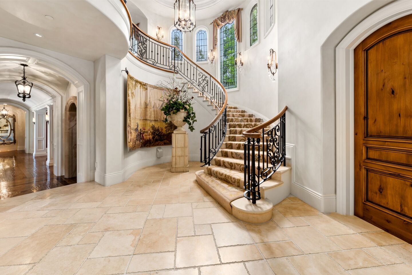 The white foyer leads to a staircase and a hallway.