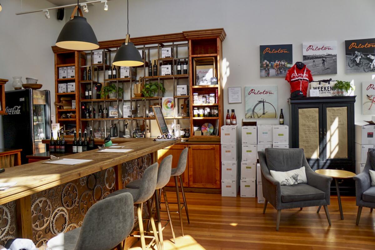 A tasting room with a bar and cases of wine piled against the wall