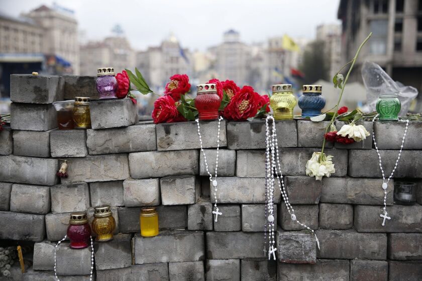 Flowers, candles and beads are left for people of the "Maidan movement" at an improvised wall made of pavement stones at Independence Square in Kiev.