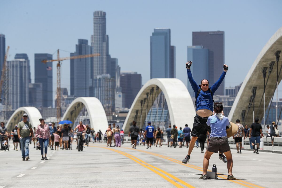 John Lopker leaps for a photo by Hae Jeong Kim as they visit the Sixth Street Viaduct