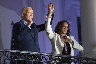 El presidente estadounidense Joe Biden alza la mano de la vicepresidenta Kamala Harris tras observar los fuegos artificiales lanzados por el Día de la Independencia desde el balcón de la Casa Blanca, el jueves 4 de julio de 2024, en Washington. (AP Foto/Evan Vucci)