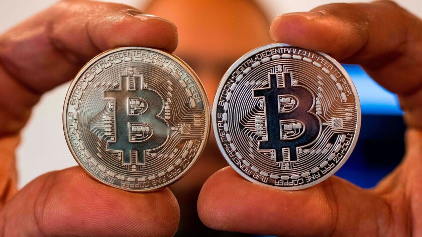 A person holds tokens bearing the bitcoin logo.