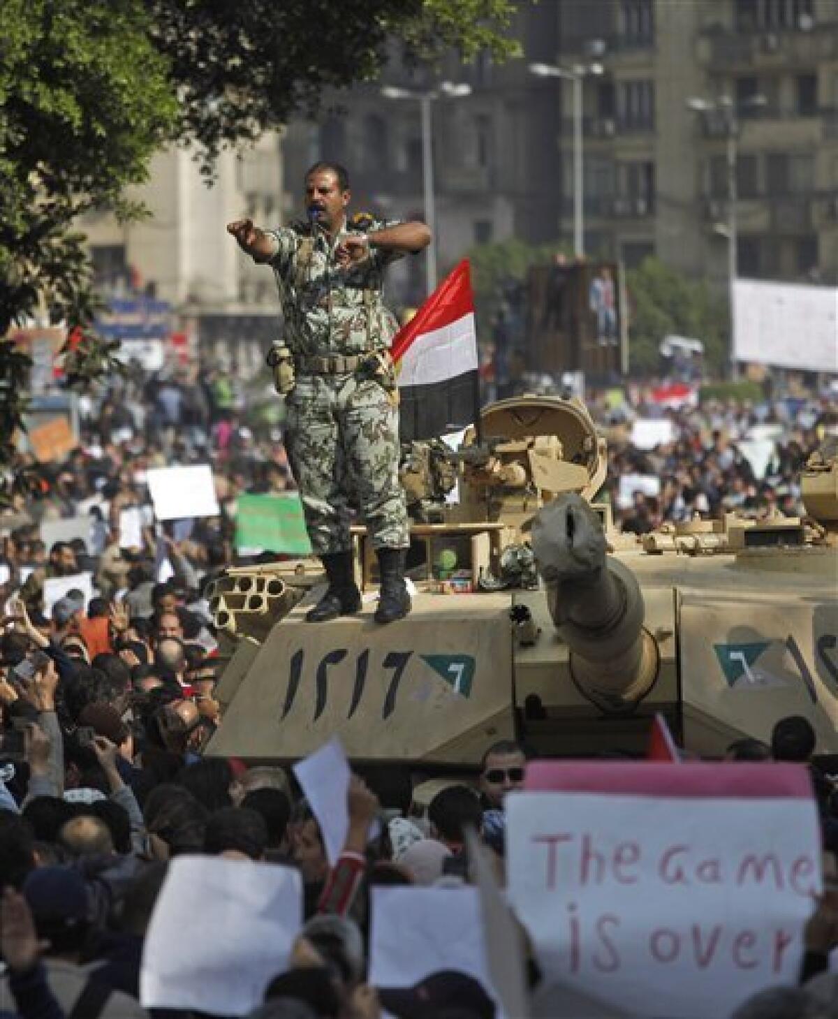 An Egyptian army Lieutenant Colonel stands on top of a tank, as demonstrators arrive in Tahrir, or Liberation, Square in Cairo, Egypt, Tuesday, Feb. 1, 2011. More than a quarter-million people flooded into the heart of Cairo Tuesday, filling the city's main square in by far the largest demonstration in a week of unceasing demands for President Hosni Mubarak to leave after nearly 30 years in power. (AP Photo/Emilio Morenatti)