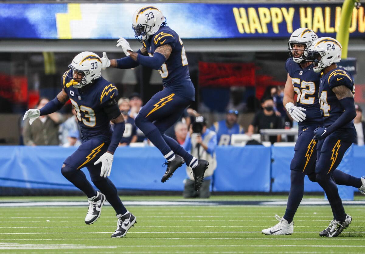 Chargers free safety Derwin James (33) and cornerback Ryan Smith (23) celebrate after stopping the New England Patriots.