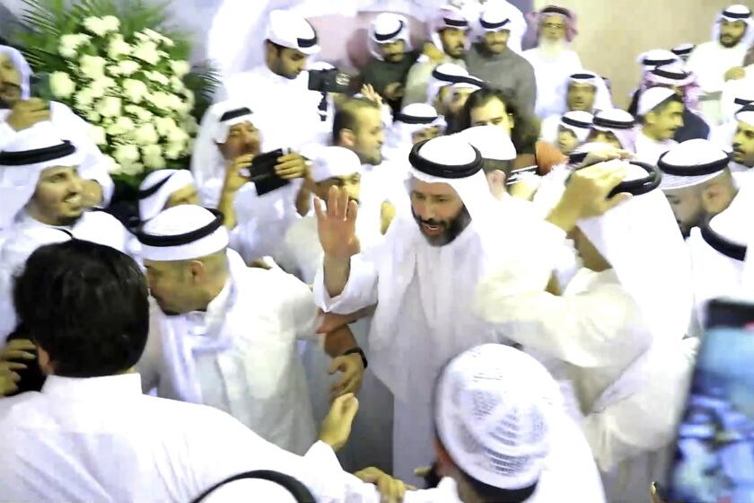 In this frame grab from video, pardoned Islamist lawmaker Faisal al-Muslim waves to supporters at a celebration marking his return to Kuwait, in Kuwait City, Kuwait, Tuesday, Nov. 30, 2021. Several prominent Kuwaiti opposition figures have returned home from a decade of self-exile after getting amnesty from the ruling emir, a long-awaited move celebrated Tuesday that's aimed at ending the political paralysis that has burned a hole in public finances. (AP Photo)