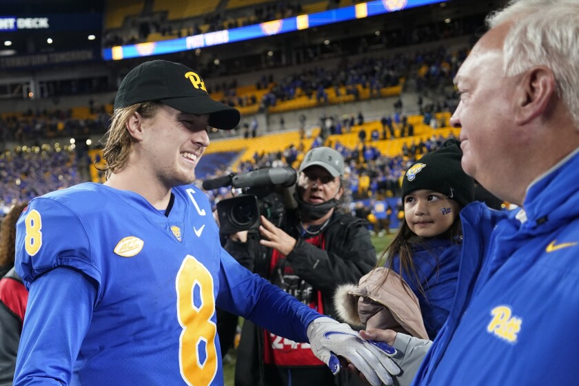 Pittsburgh quarterback Kenny Pickett (8) greets offensive coordinator Mark Whipple after the team's win over Virginia in an NCAA college football game to clinch the Atlantic Coast Conference Coastal Division championship, Saturday, Nov. 20, 2021, in Pittsburgh. (AP Photo/Keith Srakocic)