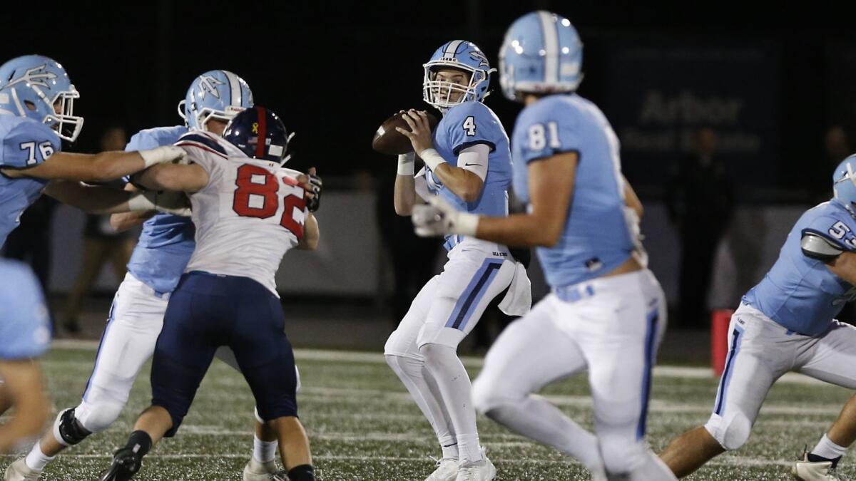 Corona del Mar quarterback Ethan Garbers (4) spots tight end Mark Redman (81) downfield during a playoff game on Nov. 10.