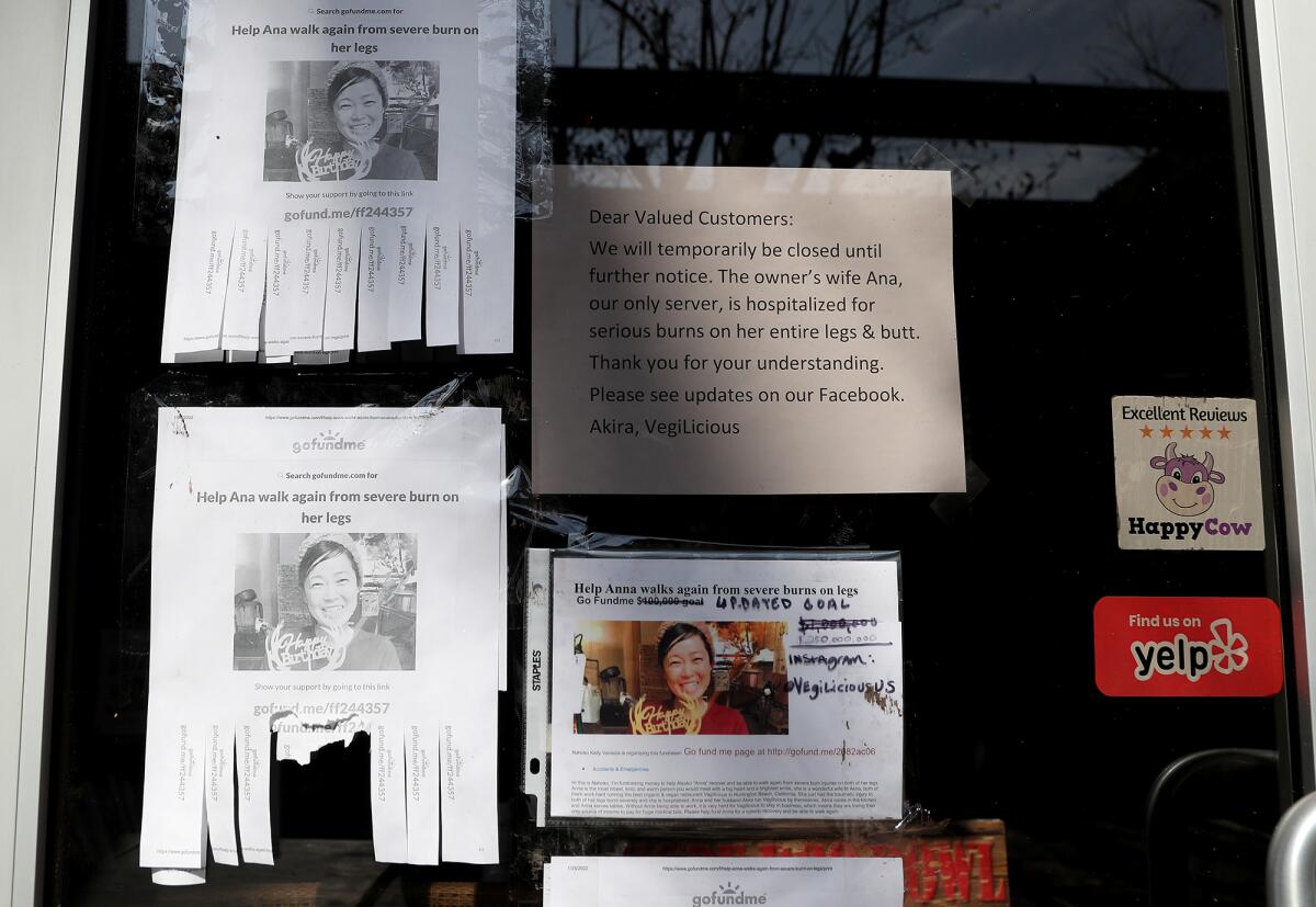 GoFundMe signs posted in front of VegiLicious restaurant's window.