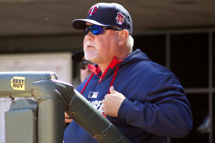 Twins manager Ron Gardenhire flashes signals during a game against the Oakland A's.