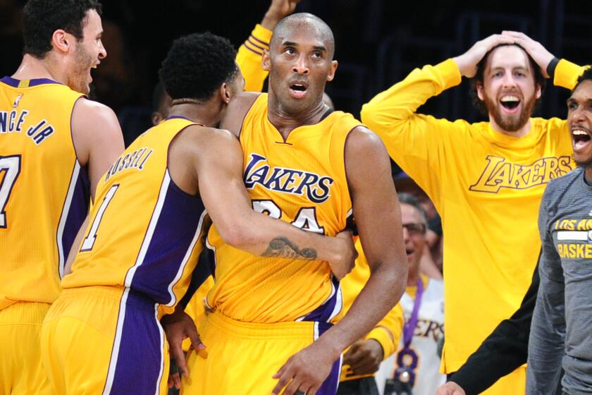 Lakers Kobe Bryant is mobbed by teammates after he scores 60-points in his final NBA game