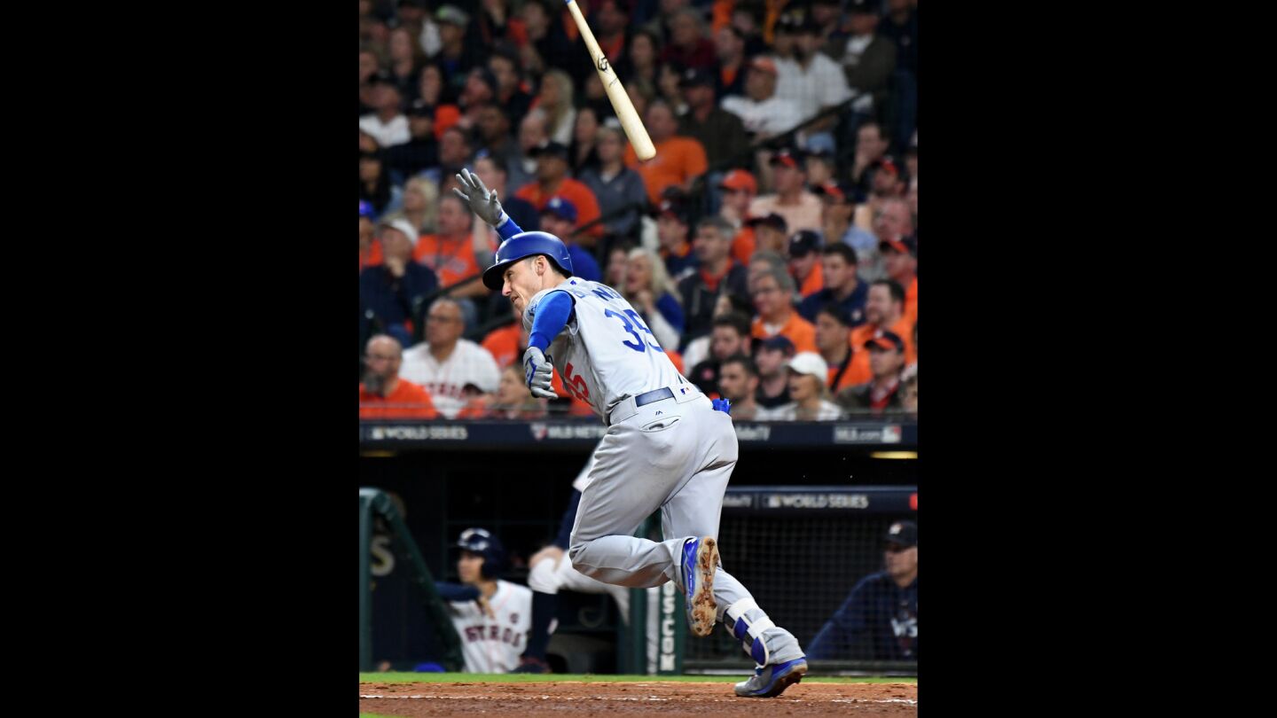 Cody Bellinger of the Dodgers tosses his bat after hitting an RBI double in the ninth inning.