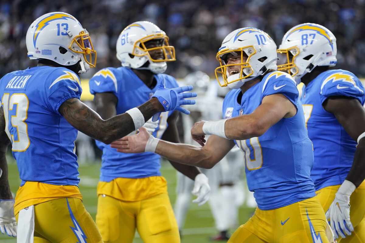 Los Angeles Chargers quarterback Justin Herbert, second from right, reacts after a touchdown during the first half of an NFL football game against the Las Vegas Raiders, Monday, Oct. 4, 2021, in Inglewood, Calif. (AP Photo/Marcio Jose Sanchez)
