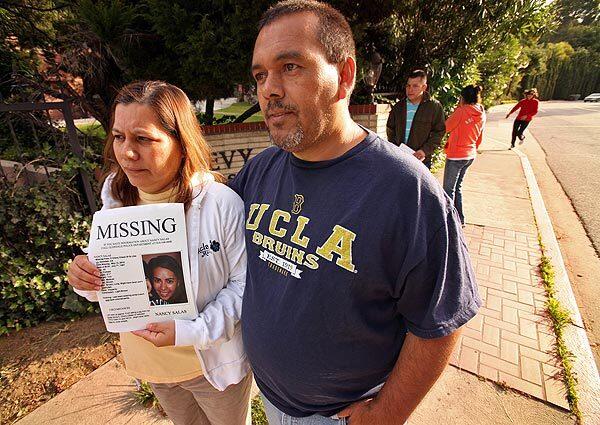 Joanna and Henry Salas walk along Chevy Chase Drive in Glendale early Thursday with fliers featuring a photo of their daughter, Nancy, 22, who had gone missing Wednesday. She was found Thursday in Merced, Calif., where she told authorities that she had been kidnapped. Late Thursday, Salas told Glendale police that she had made up the story of the kidnapping. See full story