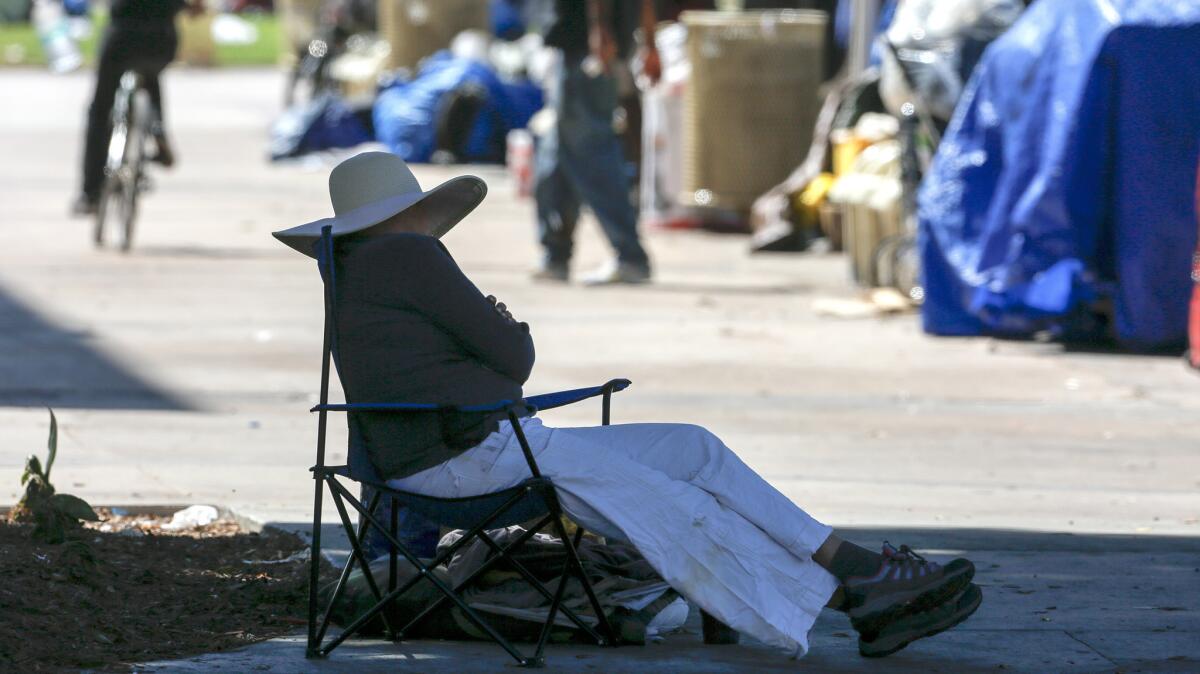 Homeless people gather near their campsites in the Santa Ana Civic Center Plaza.