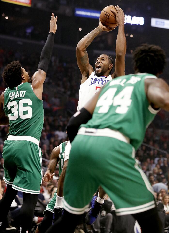 Clippers forward Kawhi Leonard shoots over Celtics guard Marcus Smart during the second quarter of a game Nov. 20 at Staples Center.