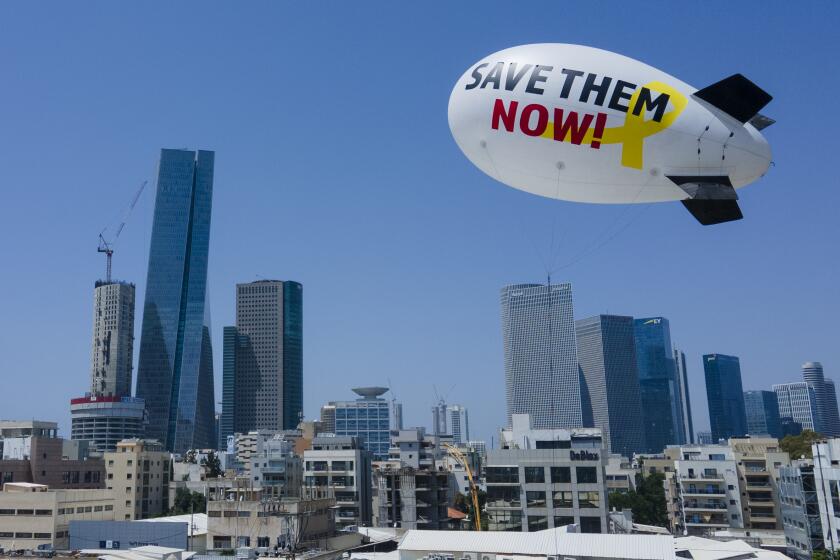 Family and friends of the remaining hostages held in the Gaza Strip by the Hamas militant group launch a small blimp calling for their release in Tel Aviv, Israel, Sunday, June 9, 2024. On Saturday, Israel rescued four hostages who were kidnapped in the Hamas-led attack on Oct. 7, the largest such recovery operation since the war began in Gaza. (AP Photo/Ariel Schalit)