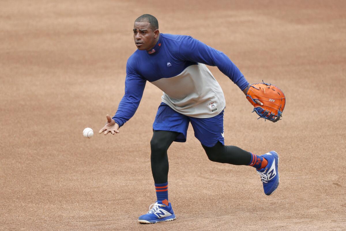 New York Mets outfielder Yoenis Cespedes fields balls at first base in a summer training camp workout July 22 in New York.