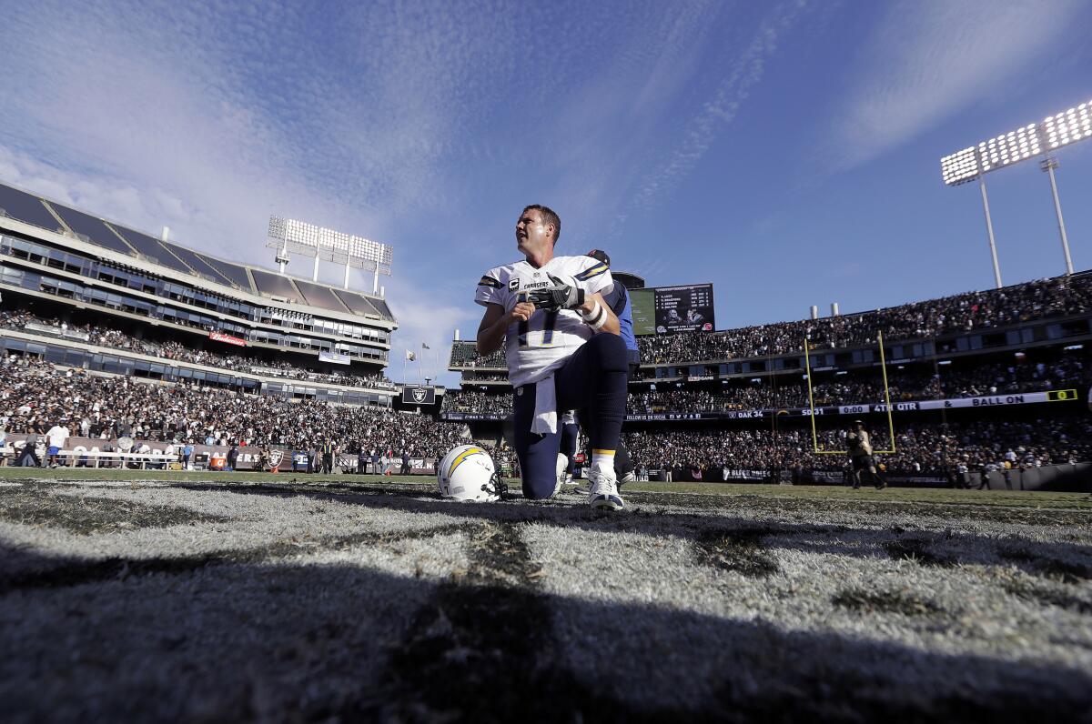 Chargers quarterback Philip Rivers kneels after a game against the Raiders on Oct. 12, 2016 in Oakland.