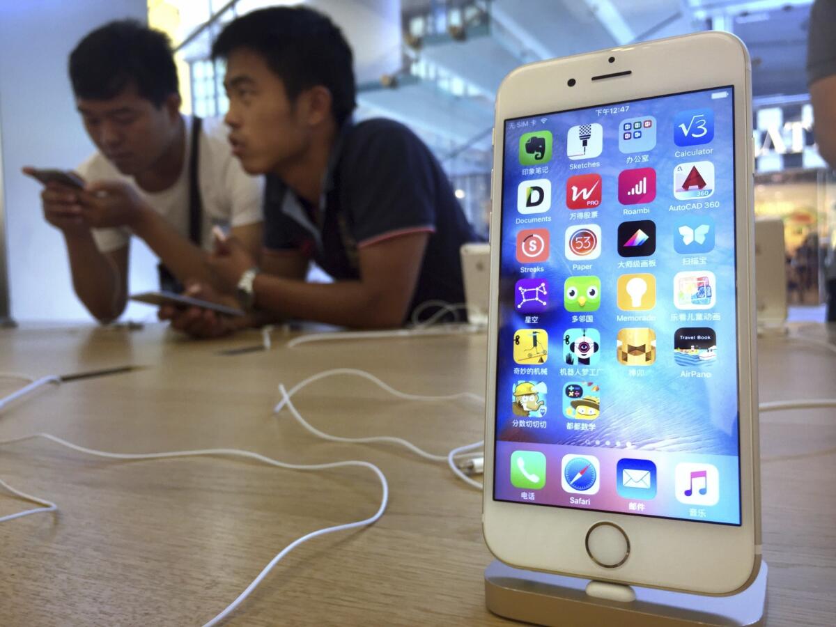 Clientes mirando modelos del iPhone 6S de Apple en una tienda de la marca en Beijing, El director ejecutivo de Apple, Tim Cook, dijo que espera que la actualización de software ayude a aliviar una escasez de donación de órganos endémica.(AP Foto/Mark Schiefelbein)