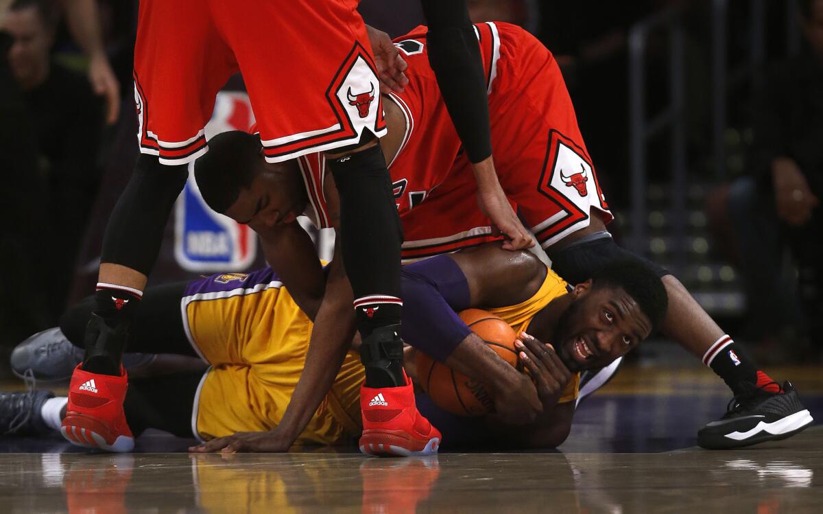 Lakers center Roy Hibbert is surrounded by Bulls defenders Taj Gibson and E'Twwaun Moore as he holds onto a loose ball while on the floor during a Jan. 28 game at Staples Center.