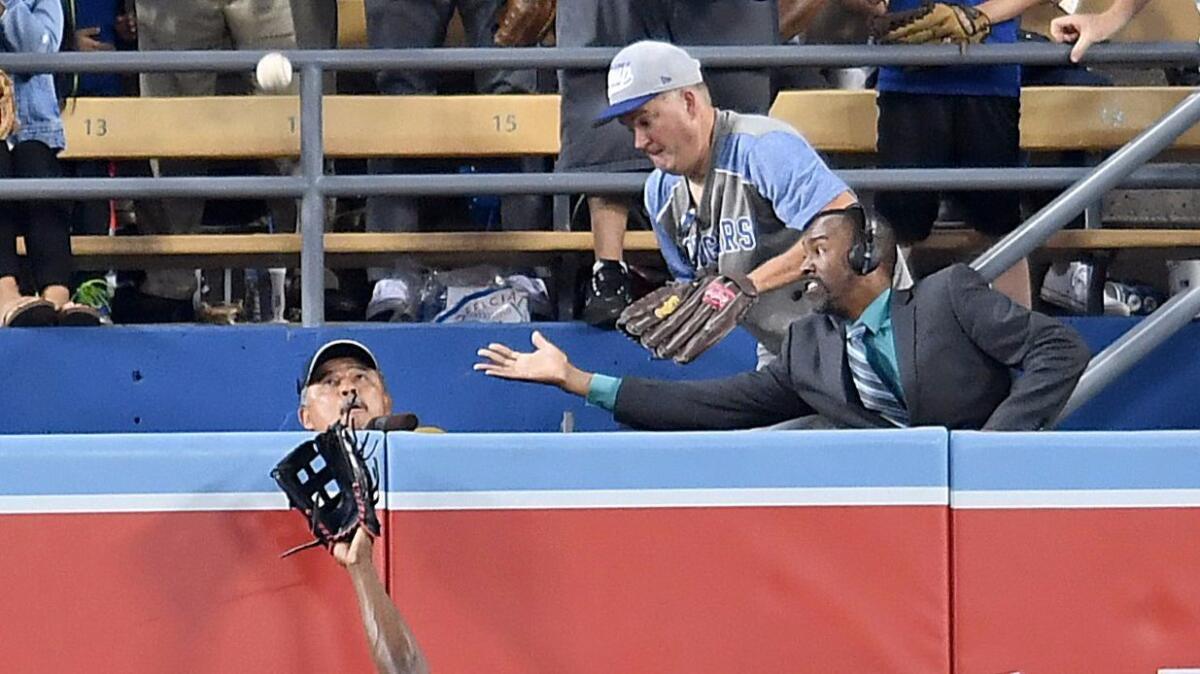 Dodger vendor Robert E. Sanchez looks up last year as a home run ball hit by Dodgers shortstop Corey Seager flies toward him.