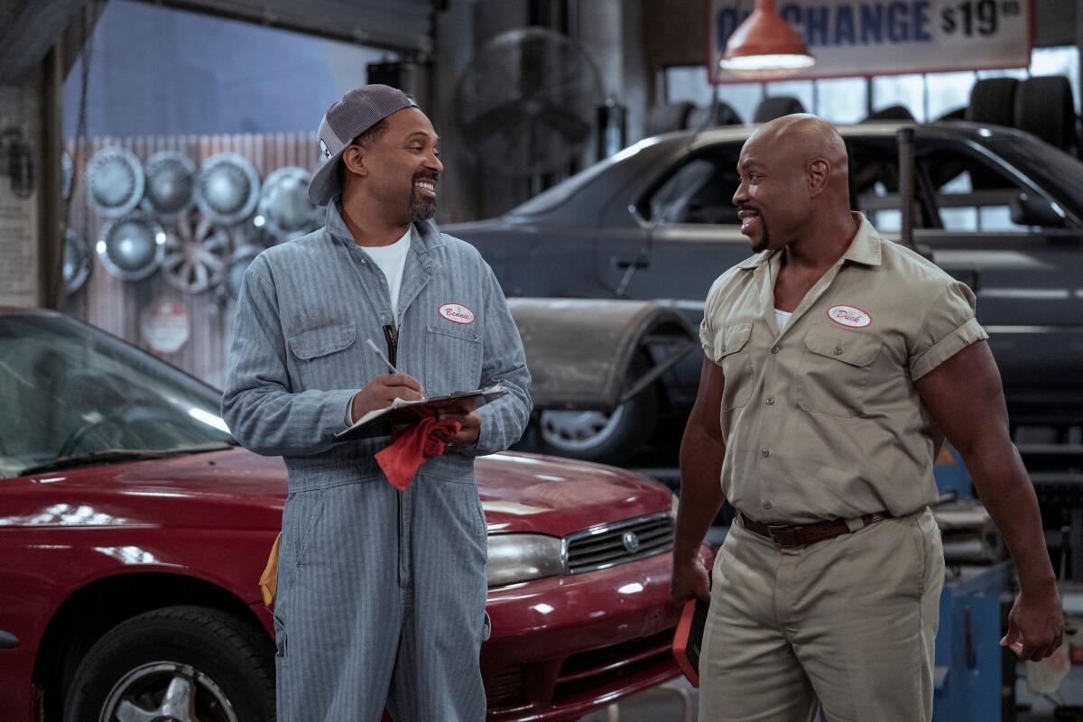 Two mechanics in an auto body shop