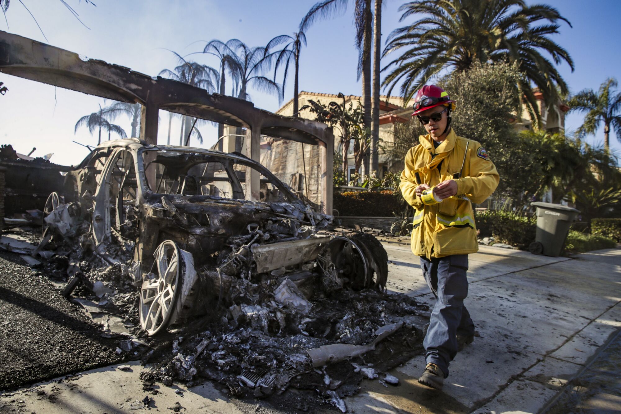OCFA Capt. Brian Yau puts caution tape around unsafe homes gutted by Coastal fire in Laguna Niguel.