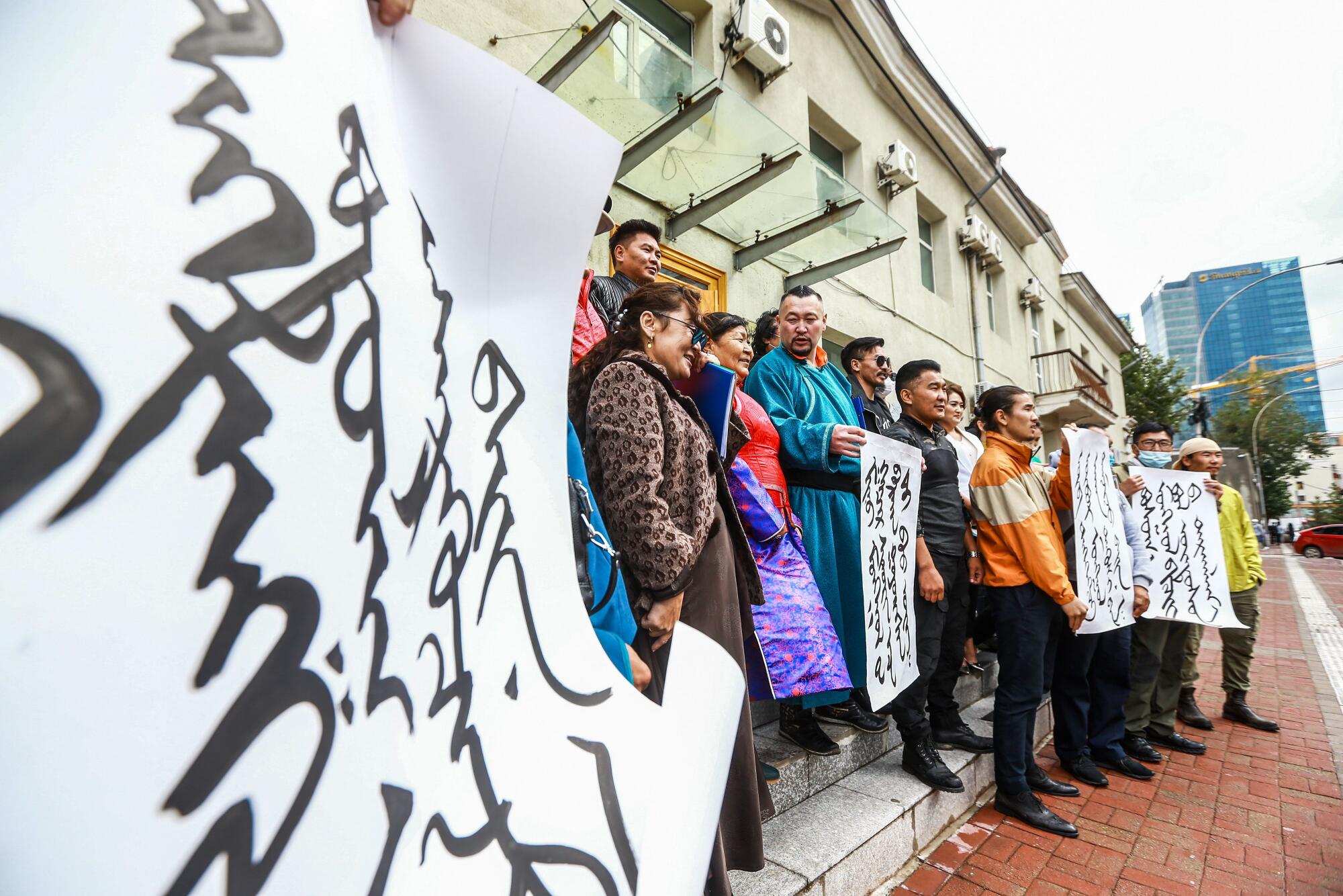 Mongolians hold protest signs at the Foreign Ministry in Ulan Bator, the capital.